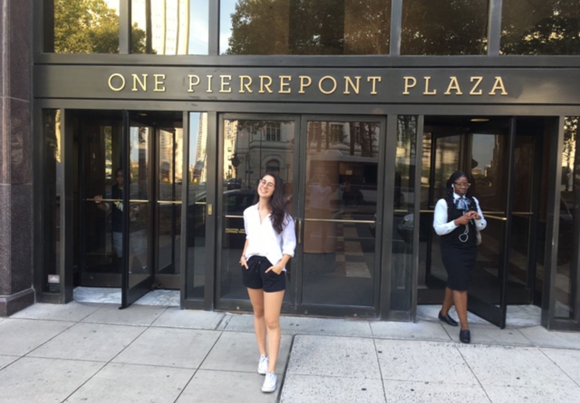 Photo of Naz in front of main entrance, with revolving doors, of One Pierrepont Plaza